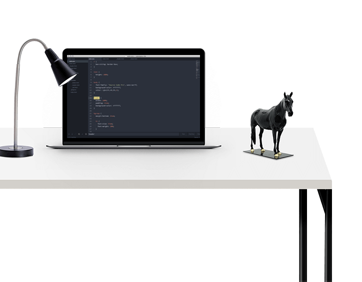 There is a table on which a horse is placed and a laptop is also placed on it